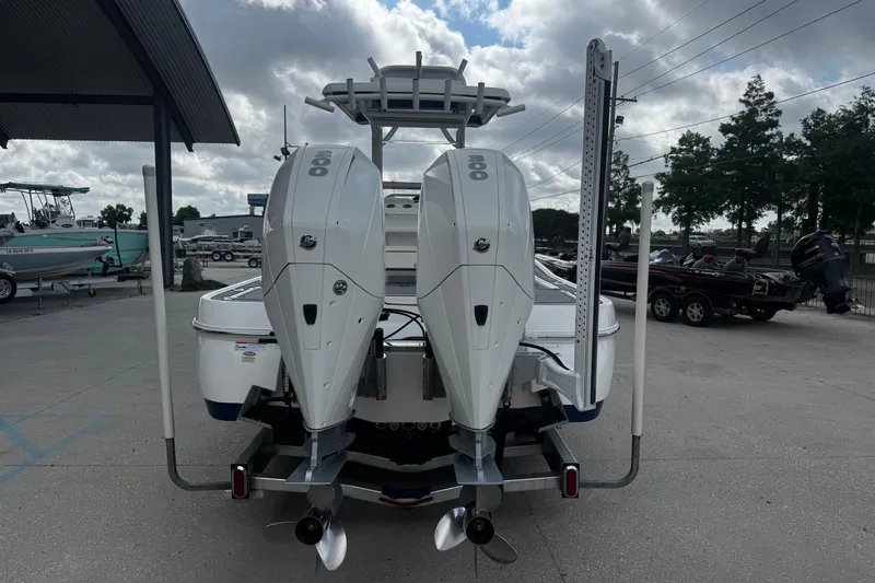 Slide: The Image of 2021 Caymas 28 HB boat with dual 300 horsepower engines, parked outdoors under cloudy skies. - 5