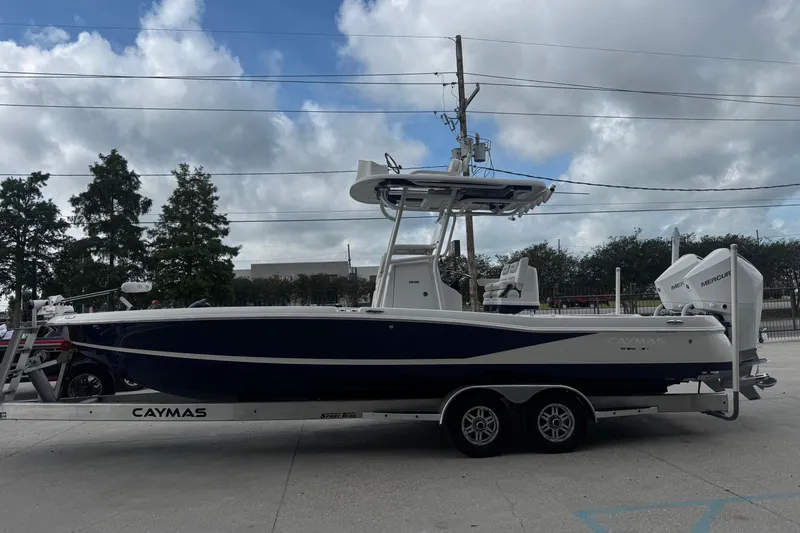 Slide: The Image of 2021 Caymas 28 HB boat on trailer, parked outdoors under cloudy sky. - 7
