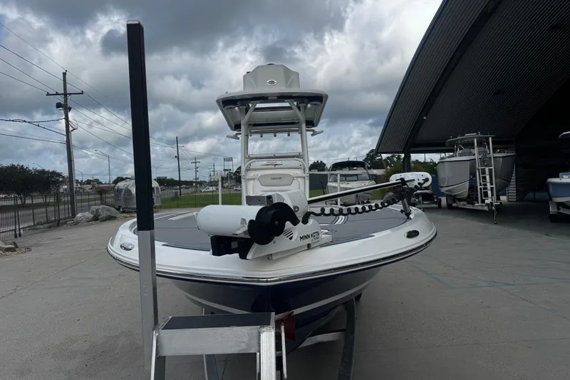 Slide: The Image of 2021 Caymas 28 HB boat with Minn Kota trolling motor, parked outdoors under cloudy skies. - 9
