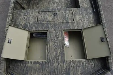 Slide: The Image of 2025 Lowe Roughneck 1860SC boat storage compartments with open hatches, showcasing camouflage design. - 10