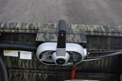 Slide: The Image of 2025 Lowe Roughneck 1860SC boat control panel with camouflage design and throttle lever. - 18
