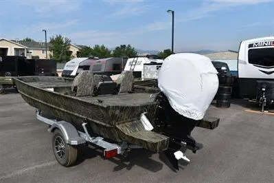 Slide: The Image of 2025 Lowe Roughneck 1860SC boat on trailer, parked outdoors, with covered outboard motor. - 4