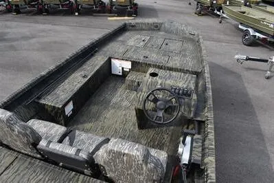 Slide: The Image of 2025 Lowe Roughneck 1860SC boat interior with camouflage design and steering console. - 7
