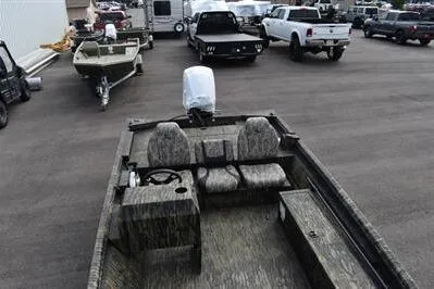Slide: The Image of 2025 Lowe Roughneck 1860SC boat with camo seats in a parking lot. - 8