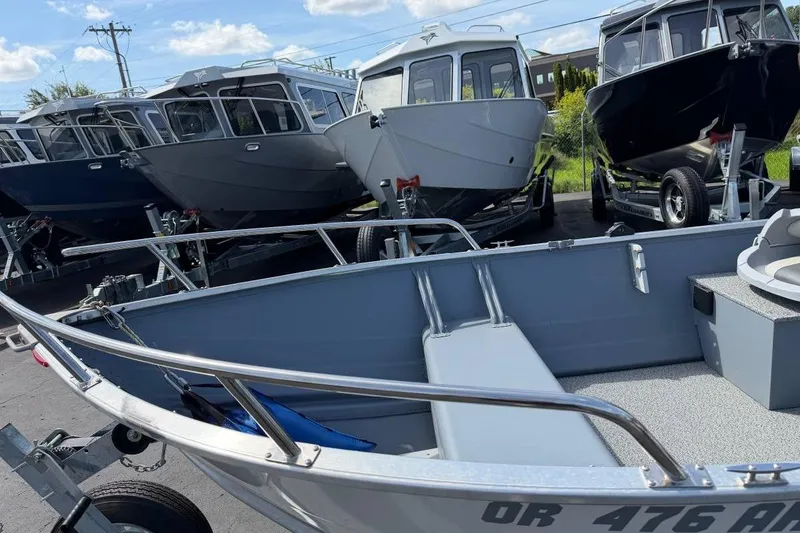 Slide: The Image of 2023 Smoker Craft Alaskan 15 boat displayed among other boats in a dealership lot. - 11