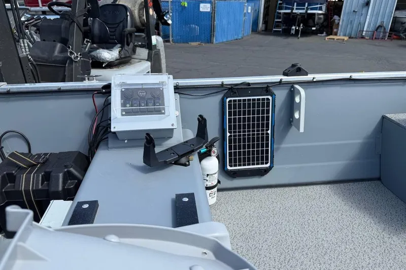 Slide: The Image of 2023 Smoker Craft Alaskan 15 boat interior with control panel and solar charger. - 8