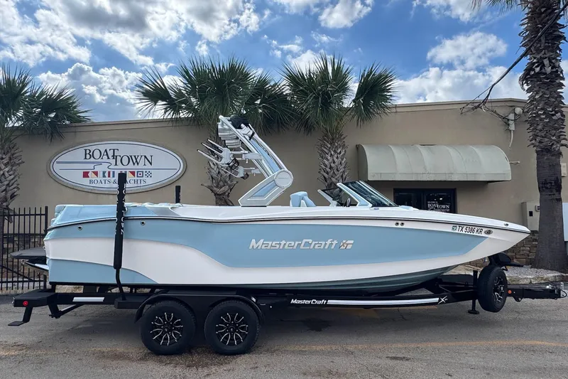 The Image of 2023 MasterCraft XT24 boat on trailer at Boat Town dealership. - 1