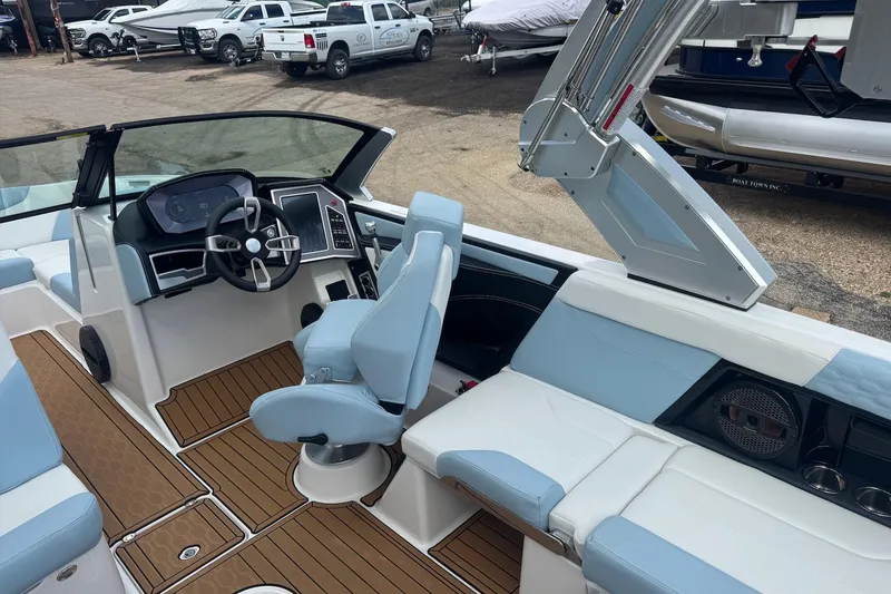 Slide: The Image of 2023 MasterCraft XT24 boat interior with modern helm, blue seating, and wood-style flooring. - 10
