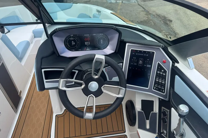 Slide: The Image of 2023 MasterCraft XT24 boat dashboard with modern controls and sleek steering wheel design. - 11