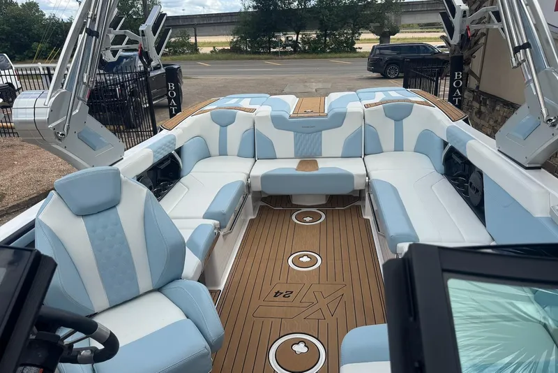 Slide: The Image of 2023 MasterCraft XT24 boat interior with blue and white seating, teak flooring. - 15