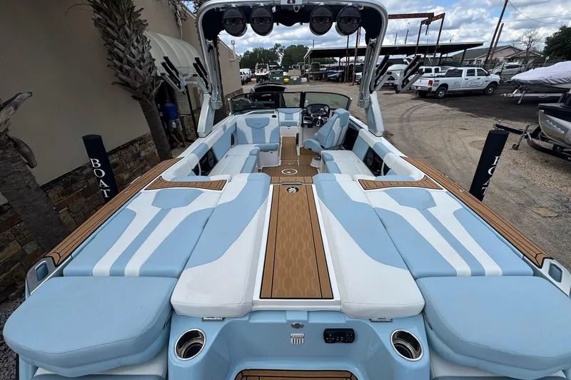 Slide: The Image of 2023 MasterCraft XT24 boat with luxurious seating and modern design in a marina setting. - 6