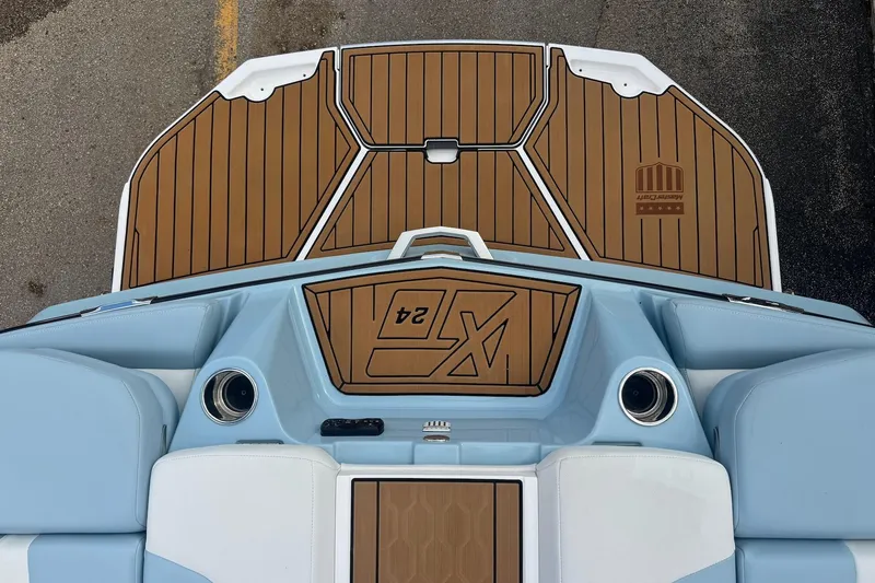 Slide: The Image of 2023 MasterCraft XT24 boat deck with teak-style flooring and blue seating. - 7