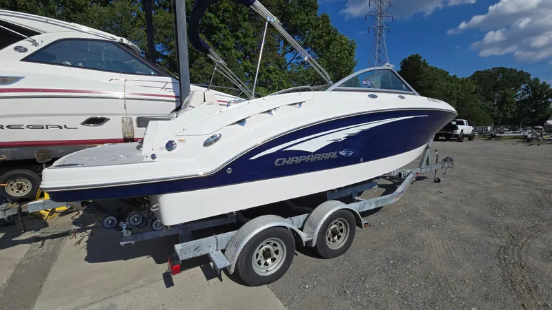 The Image of 2018 Chaparral 224 Sunesta boat on trailer, parked outdoors under blue sky. - 0