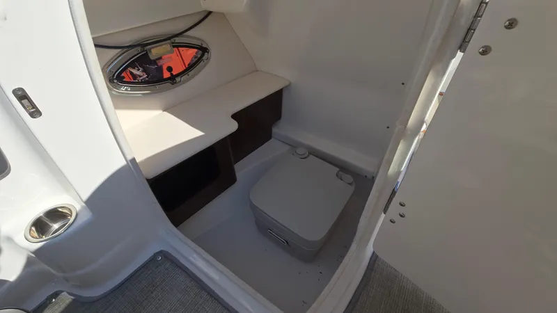 Slide: The Image of 2018 Chaparral 224 Sunesta boat interior with compact toilet and window. - 39