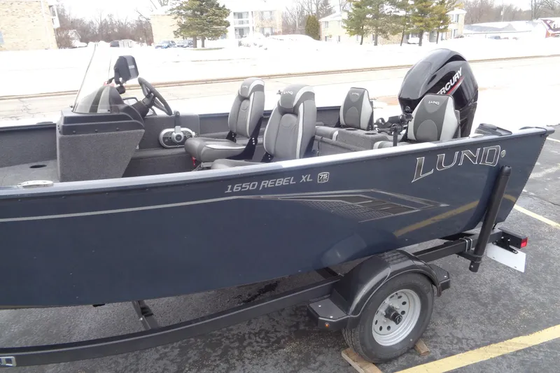 Slide: The Image of 2023 Lund 1650 Rebel XL SS boat with Mercury engine, parked on a trailer. - 2