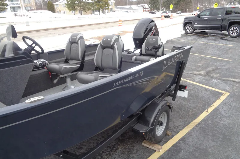 Slide: The Image of 2023 Lund 1650 Rebel XL SS boat in parking lot, featuring modern seating and design. - 3