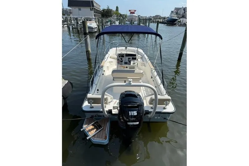 Slide: The Image of 2025 Boston Whaler 170 Montauk boat docked, featuring a 115 HP Mercury engine. - 1