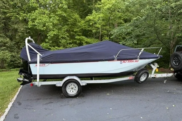 Slide: The Image of 2025 Boston Whaler 170 Montauk boat on trailer, covered, parked on driveway. - 10
