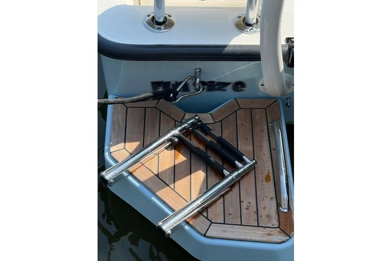 Slide: The Image of 2025 Boston Whaler 170 Montauk swim platform with folded ladder and teak finish. - 6