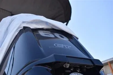 Slide: The Image of 2025 Lowe LS 170 boat engine, 60 GT model, partially covered, under clear sky. - 12