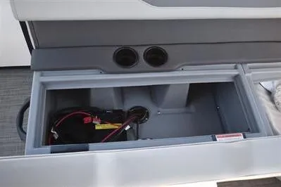 Slide: The Image of Open storage compartment in a 2025 Lowe LS 170 boat, featuring battery and wiring. - 23