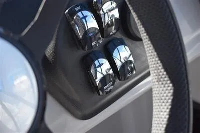 Slide: The Image of Close-up of 2025 Lowe LS 170 boat control panel with switches and steering wheel. - 29