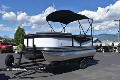 Slide: The Image of 2025 Lowe LS 170 pontoon boat on trailer under clear blue sky. - 3