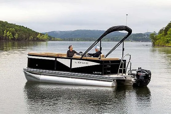 Slide: The Image of Manufacturer Provided Image: 2025 Lowe LS 170 pontoon boat on a serene lake with two passengers. - 32