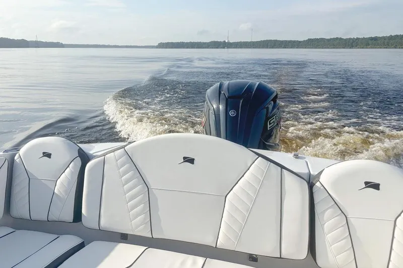 Slide: The Image of Stingray 23 OSX 2026 boat on calm water with motor. - 2
