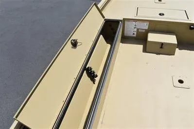 Slide: The Image of 2025 Lowe Roughneck 1860 boat storage compartment, open lid, beige interior, organized layout. - 13