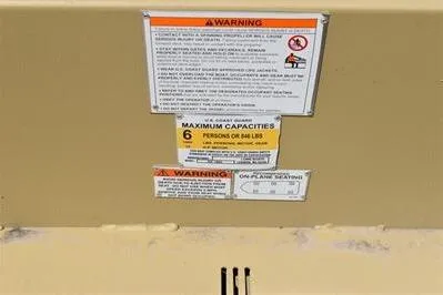 Slide: The Image of Warning labels on 2025 Lowe Roughneck 1860 boat, maximum capacity: 6 persons or 848 lbs. - 16