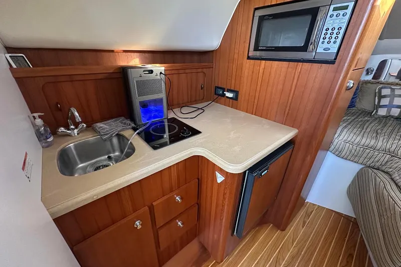 Slide: The Image of Compact kitchen area in a 2005 Tiara 2900 Open boat with sink, stove, and microwave. - 10