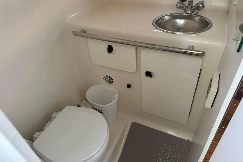 Slide: The Image of 2005 Tiara 2900 Open boat bathroom with toilet, sink, and storage cabinets. - 15