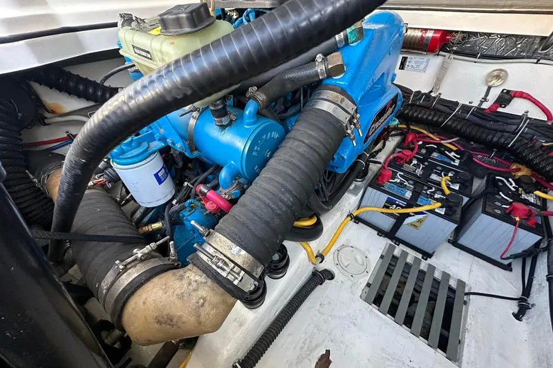 Slide: The Image of Engine compartment of a 2005 Tiara 2900 Open boat, featuring a blue engine and batteries. - 19