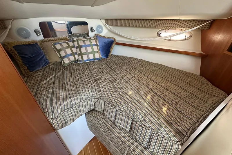 Slide: The Image of Cozy cabin interior of 2005 Tiara 2900 Open with striped bedding and decorative pillows. - 5
