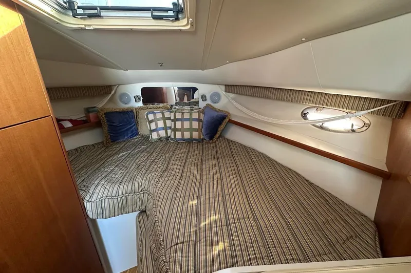 Slide: The Image of Cozy cabin interior of 2005 Tiara 2900 Open yacht with striped bedding and cushions. - 9