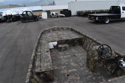 Slide: The Image of 2025 Lowe Roughneck 1860 Rambler boat in a parking lot, showcasing camo design and spacious interior. - 6