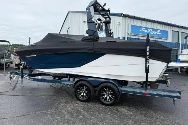 Slide: The Image of 2022 Nautique Super Air Nautique G21 boat on trailer, covered, outside dealership. - 10