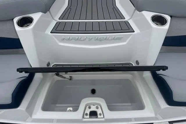 Slide: The Image of 2022 Nautique Super Air Nautique G21 boat interior with storage compartment and cup holders. - 33