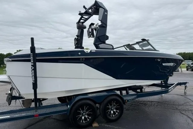 Slide: The Image of 2022 Nautique Super Air Nautique G21 boat on trailer, sleek design, dark blue and white color. - 7