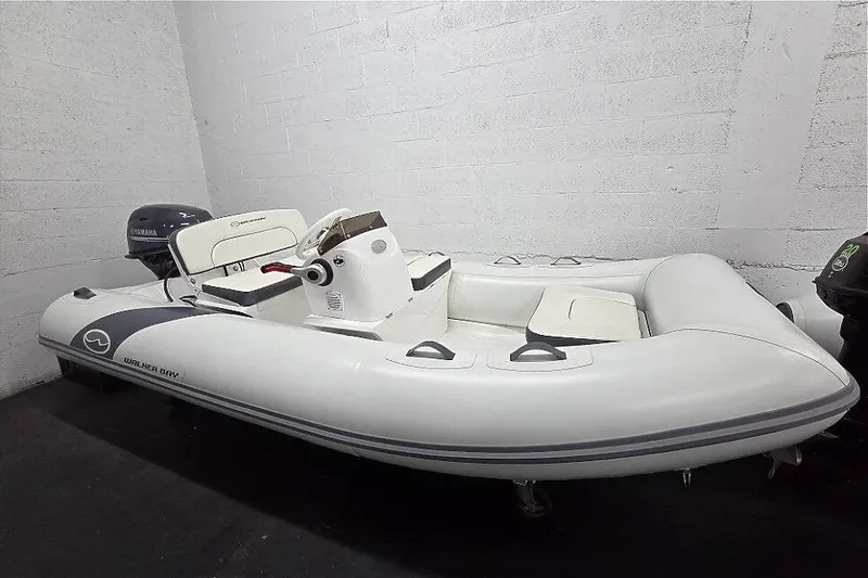 The Image of 2023 Walker Bay 365 STX inflatable boat with Yamaha motor in a garage setting. - 1