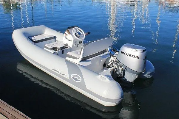 Slide: The Image of 2023 Walker Bay 365 STX inflatable boat with Honda outboard motor on calm water. - 10