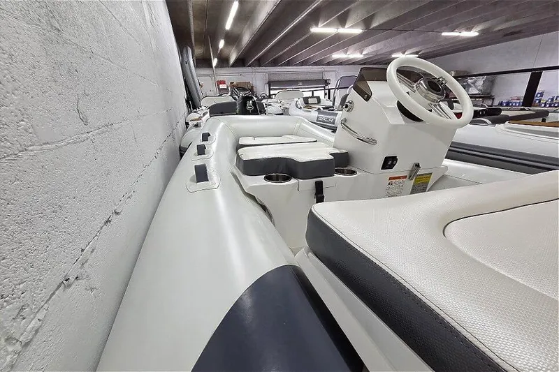 Slide: The Image of 2023 Walker Bay 365 STX boat interior with steering console in a warehouse setting. - 3