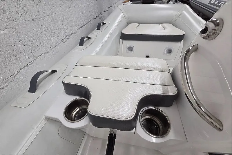 Slide: The Image of 2023 Walker Bay 365 STX boat interior with cushioned seating and cup holders. - 5