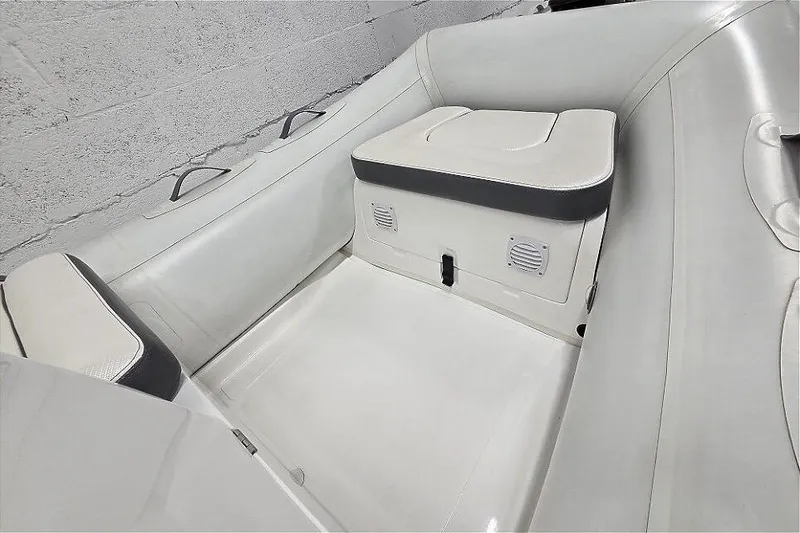 Slide: The Image of 2023 Walker Bay 365 STX boat interior with cushioned seating and storage compartment. - 8