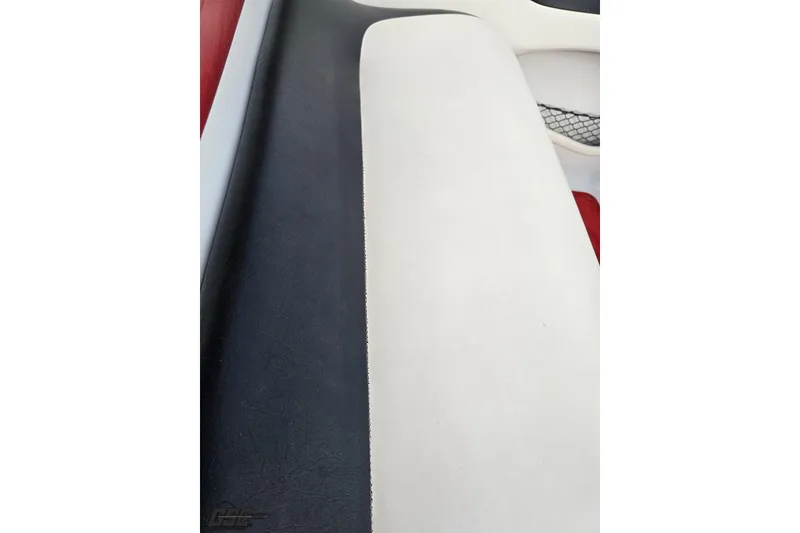 Slide: The Image of Interior seating of a 2004 Baja 275 boat, featuring black and white upholstery. - 100