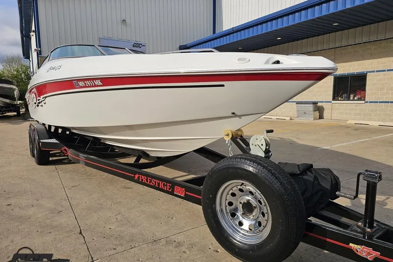 Slide: The Image of 2004 Baja 275 boat on trailer, parked outside a building. - 12