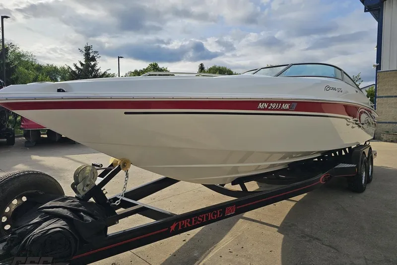 Slide: The Image of 2004 Baja 275 boat on trailer, white with red accents, parked outdoors. - 14
