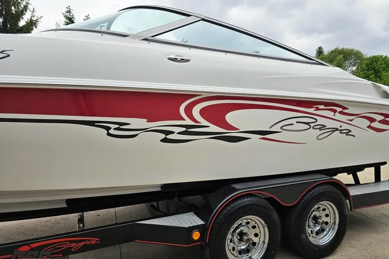 Slide: The Image of 2004 Baja 275 boat with red and black graphics on a trailer. - 19
