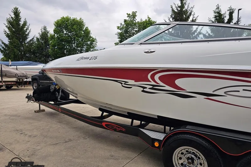 Slide: The Image of 2004 Baja 275 boat with red and black graphics on a trailer, parked outdoors. - 21